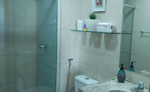 a bathroom with a shower and a toilet and a sink at Flat à beira mar, charmoso e aconchegante in João Pessoa
