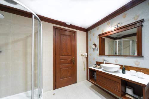 y baño con lavabo, ducha y espejo. en Hotel Bosnali en Adana