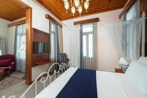 a hotel room with a bed and a tv at Hotel Bosnali in Adana