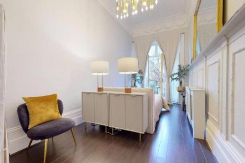 1 dormitorio con cama, escritorio y silla en Stunning Hyde Park Home with Private Balcony & Lift Elevator Access, en Londres