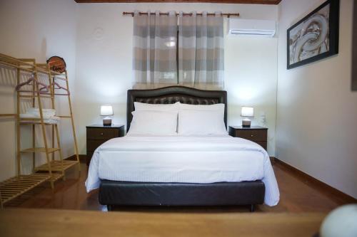 a bedroom with a bed with white sheets and a ladder at Euaggelias & Cristianas House in Aristi