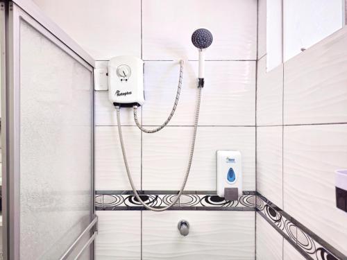 a shower with a hair dryer in a bathroom at Hospedaje Celerina & Elio in Lima