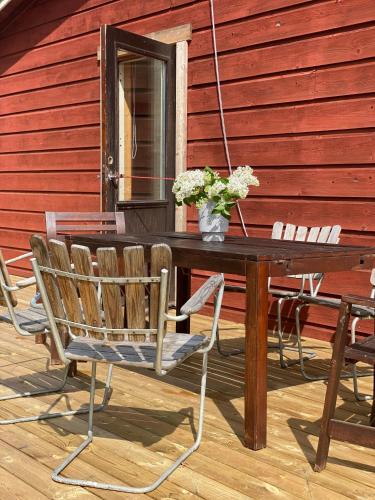a wooden table and chairs on a patio at Tjänstebostaden på Storöns bondgård in Otterbäcken