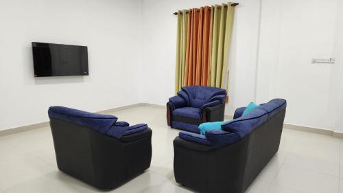 two chairs and a television in a room at Calm Guest in Trincomalee