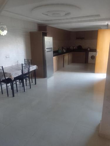 a room with a table and chairs and a kitchen at Villa en location in El Jadida