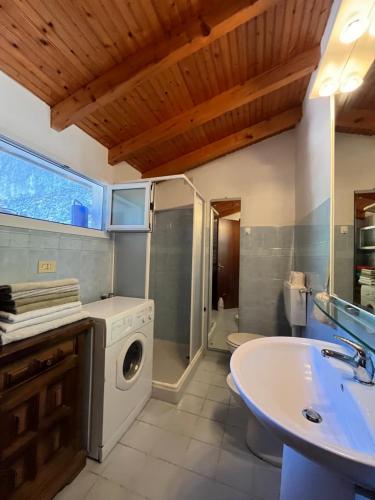 a bathroom with a washing machine and a sink at Casa Victoria - Full equipped stone house in Rocchetta Nervina
