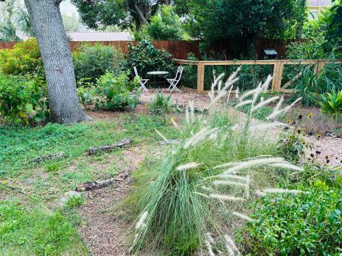 un jardín con una mesa y un banco en un patio en GardenHouse @AudubonPark Sleeps 8 en Orlando