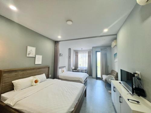 una camera d'albergo con due letti e un orsacchiotto sul letto di I Play Inn NT a Nha Trang