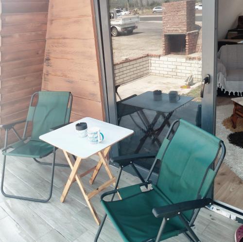 2 sillas y una mesa en un porche con mesa y sillas en İN HOUSE BUNGLOW, en Dikili