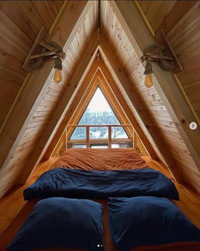 uma cama num quarto com uma grande janela em İN HOUSE BUNGLOW em Dikili