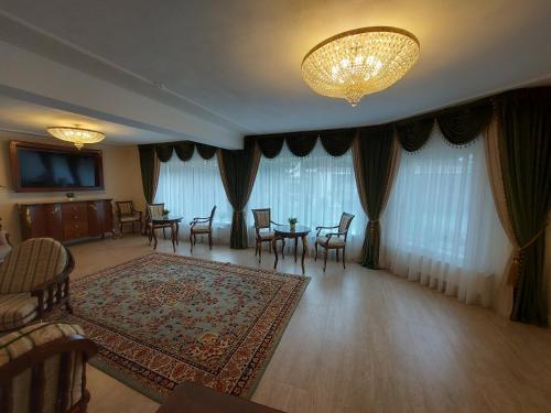 a living room with a table and chairs and a chandelier at Conacul Poetilor in Gura Rîului
