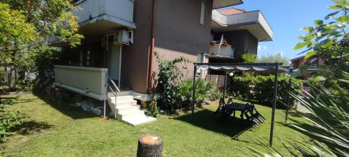 ein Hof mit einem Tisch und einem Sonnenschirm vor einem Gebäude in der Unterkunft Beach House Garden, 300m dal mare, wifi, bici, giardino privato, clima in Marina di Massa