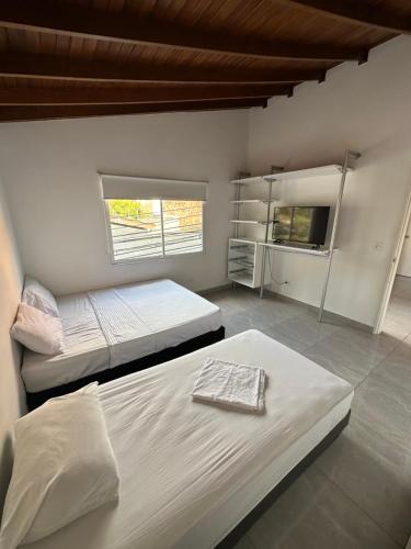 a bedroom with two beds and a tv in it at Gaston2 in Medellín