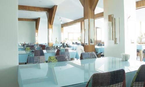 uma sala de jantar com uma mesa de vidro e cadeiras em brilliant hotel em Bolu