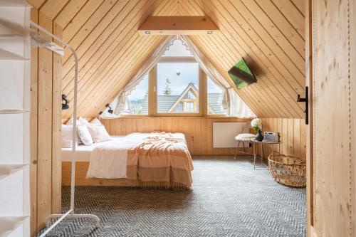 sypialnia z łóżkiem w drewnianym suficie w obiekcie Stylowa Chata w Zakopanem
