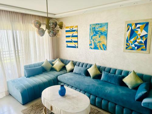 a blue couch in a living room with a table at Sidi Rahal in Sidi Rahal