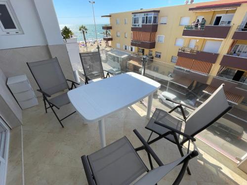 a table and chairs on the balcony of a building at Vistas al mar a 10 metros de la Playa de Regla PARKING GRATIS in Chipiona