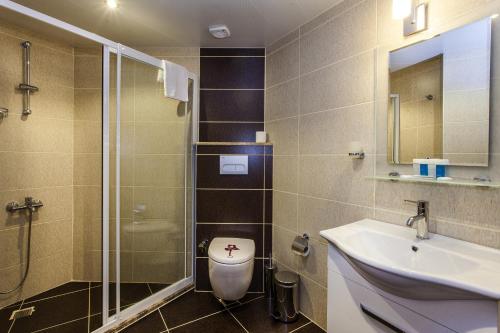 Un baño con inodoro, lavabo y ducha. en Parador Beach Hotel All Inclusive, en Alanya