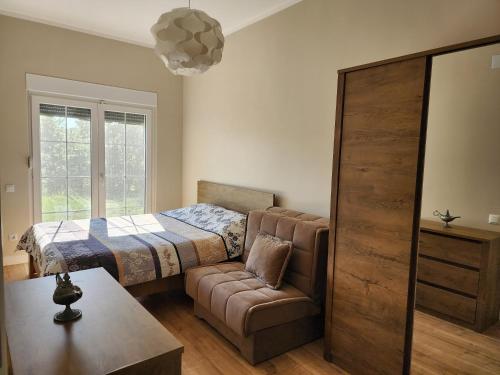 a bedroom with a bed and a couch and a chair at Shtepia e Malit in Pristina