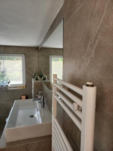 a bathroom with a sink and a bath tub at Shtepia e Malit in Prishtinë