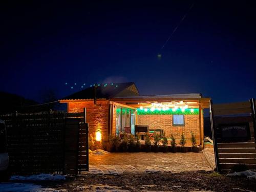 a brick house with christmas lights on it at night at eşsiz doğa manzarasında jakuzi keyfi sunan dağ evi in Gölcük