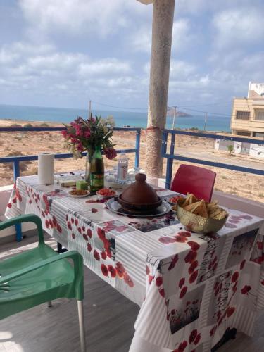 una mesa con un plato de comida en la playa en Dar Hachemia en Ras El Ma