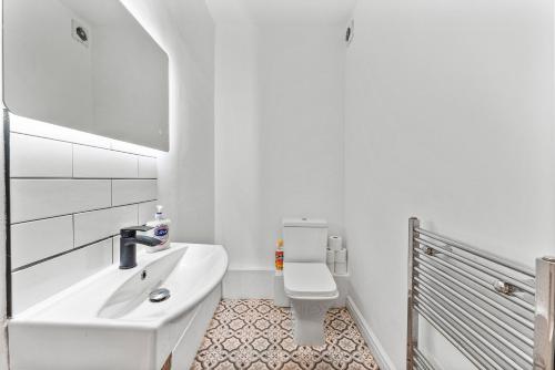een witte badkamer met een wastafel en een toilet bij 5 Mins From Leeds - 4 Bed - Parking - Sleeps 9 in Leeds