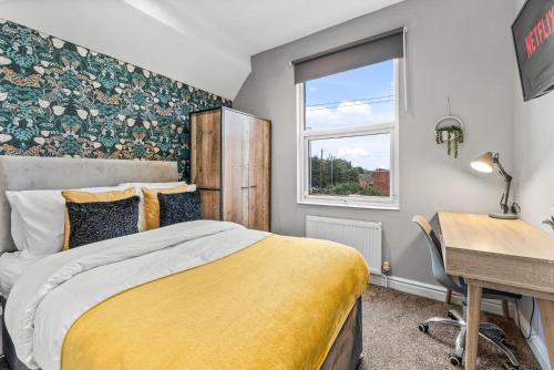 um quarto com uma cama, uma secretária e uma janela em 5 Mins From Leeds - 4 Bed - Parking - Sleeps 9 em Leeds