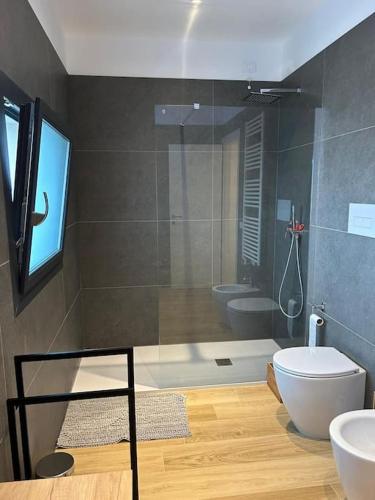a bathroom with a shower and a toilet and a sink at Villetta bifamiliare Jesolo in Jesolo
