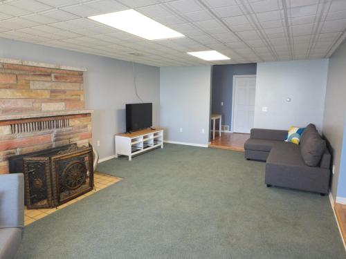 a living room with a fireplace and a couch and a tv at The Life Aquatic - Lakefront Kayaks Included! in Alpena
