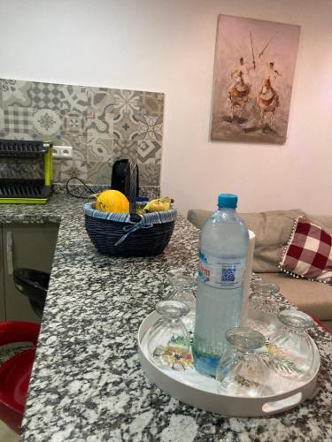 a bottle of water on a plate on a kitchen counter at Dar Hachemia in Ras El Ma