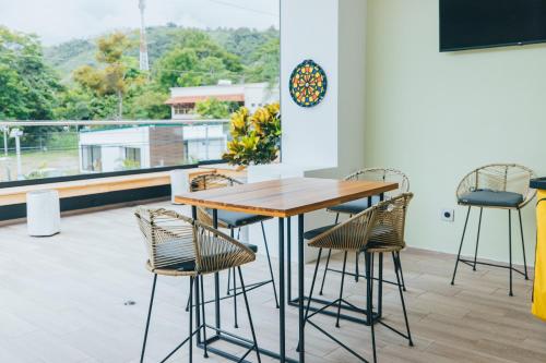 a table and chairs in a room with a balcony at Paradise Bay Hotel Boutique in Herradura