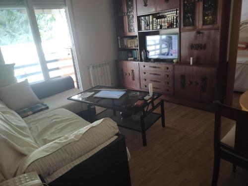 ein Wohnzimmer mit einem Couchtisch und einem TV in der Unterkunft ALQUILER DE HABITACIÓN in Madrid