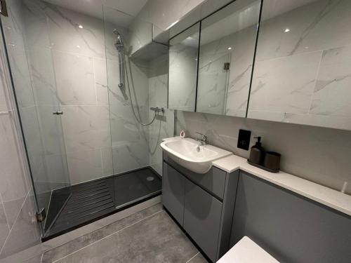 Un baño con ducha, lavabo y espejo. en Two Bedroom House In Kilburn, en Londres
