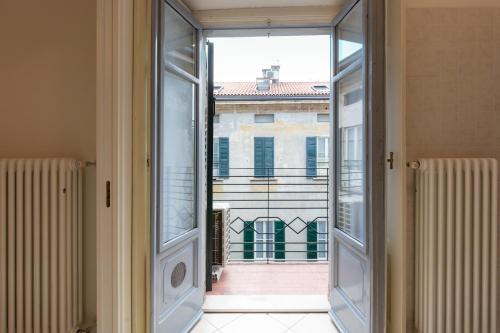 une porte en verre ouverte avec vue sur un bâtiment dans l'établissement Porta Torre Como Apartment - By Relais Di Giada, à Côme
