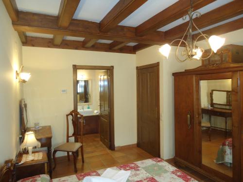 a room with a bed and a table and a mirror at Casa Felisa Pirineo Aragonés in Santa Eulalia de Gállego