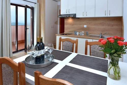 a dining room with a table with wine glasses and flowers at Apartment & rooms Vila Toplissa in Varaždinske Toplice