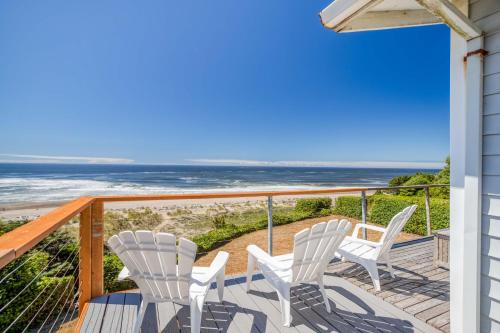 a balcony with white chairs and a view of the ocean at Star of the Sea in Lincoln City