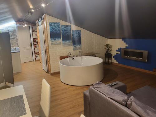 - une grande baignoire blanche dans une chambre avec un canapé dans l'établissement VT y HT arrizabalaga rural montaña, à Bermeo