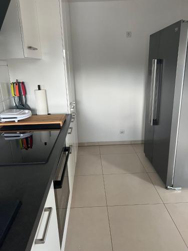 a kitchen with a black refrigerator and a tile floor at FMA Ferienwohnung Alfdorf in Alfdorf