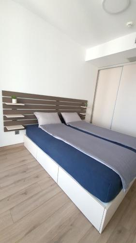 a large bed in a room with a wooden floor at 37th Floor - SkyView Oasis - C in Skopje