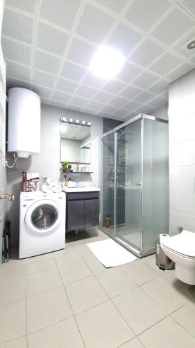 a bathroom with a washing machine and a sink at 37th Floor - SkyView Oasis - C in Skopje