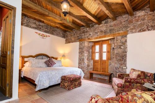 ein Schlafzimmer mit einem Bett und einer Steinmauer in der Unterkunft Hotel Amor y Paz in Real de Catorce