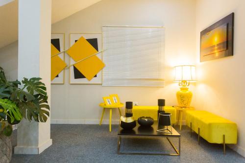 a living room with a yellow couch and a table at Kumasi Luxury Apartments @ The Fairview in Kumasi