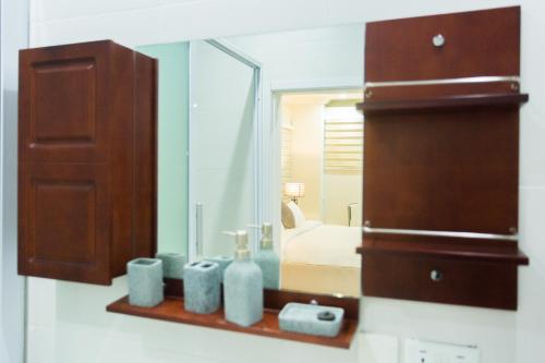 a bathroom with a mirror and a bed in a room at Kumasi Luxury Apartments @ The Fairview in Kumasi