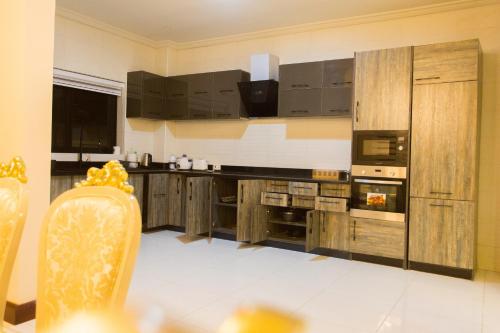 a large kitchen with wooden cabinets and a stove at Kumasi Luxury Apartments @ The Fairview in Kumasi