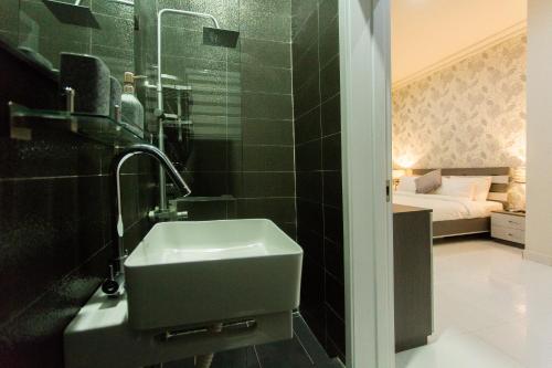 a bathroom with a sink and a bed in a room at Kumasi Luxury Apartments @ The Fairview in Kumasi