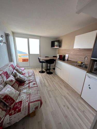 un salon avec un canapé et une cuisine avec une table dans l'établissement Sunny studio 25 m2 Mountain View balcony in Alpe d Huez district Eclose, à L'Alpe-d'Huez