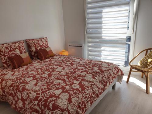 een slaapkamer met een bed, een raam en een stoel bij Magnifique appartement avec garage privé et terrasse in Reims