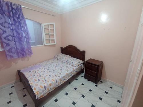 een kleine slaapkamer met een bed en een raam bij Sablettes in Oulad Akkou